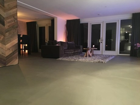 betonnen gietvloer in modern ingerichte woonkamer