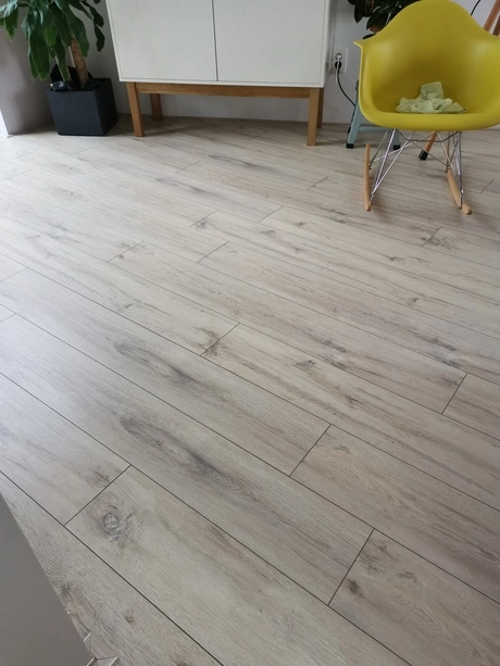 lichte houten vloer met een gele stoel