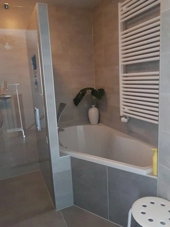 moderne badkamer met ligbad en witte tegelvloer