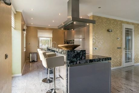 moderne keuken met marmeren bar en krukken