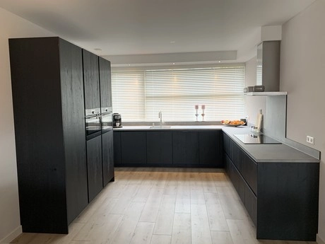 moderne keuken met zwarte kasten en lades