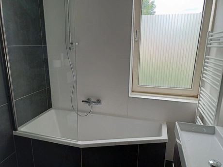 badkamer met ligbad en groot raam