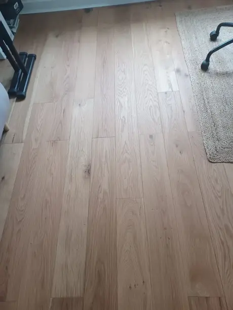 houten vloer met een rieten tapijt ernaast