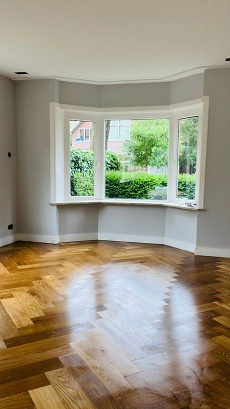 houten vloer met visgraatpatroon in zonnige kamer