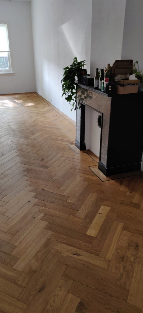 lichte kamer met houten vloer en schouw