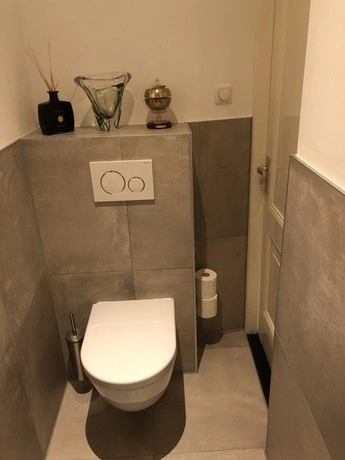 modern toilet met grijze tegels en accessoires