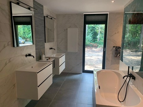 moderne badkamer met dubbele wastafel en bad