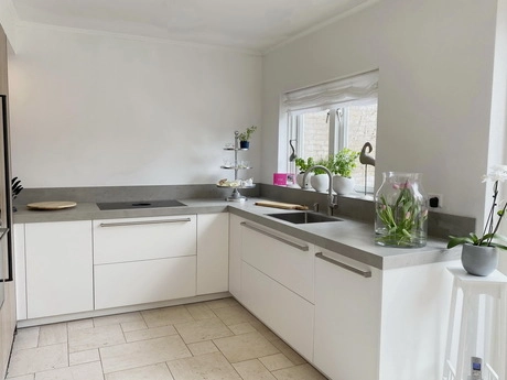 moderne witte keuken met grijze aanrechtbladen