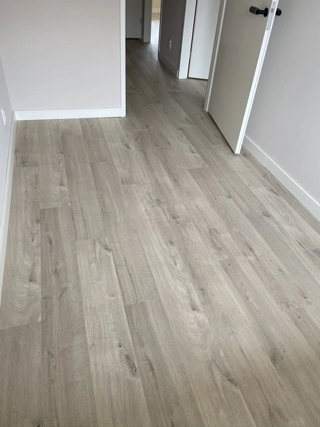 houten vloer in een lichte gang met deuren