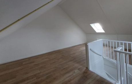 lege kamer met houten vloer en dakraam