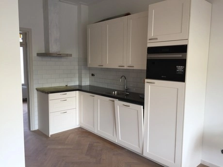 witte keuken met moderne apparaten en gootsteen