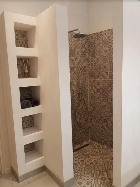 moderne douche met decoratieve betegeling en planken