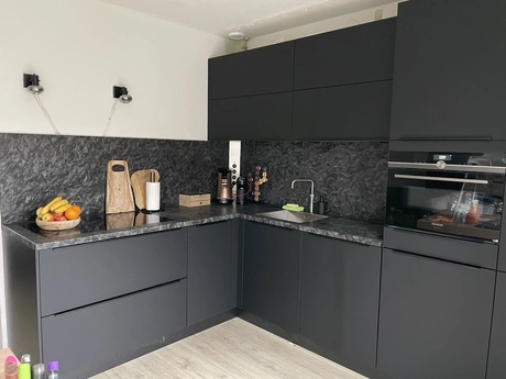 moderne keuken met donkere kastjes en apparatuur