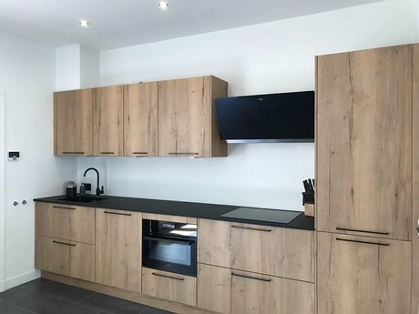 moderne keuken met houten kasten en zwarte details