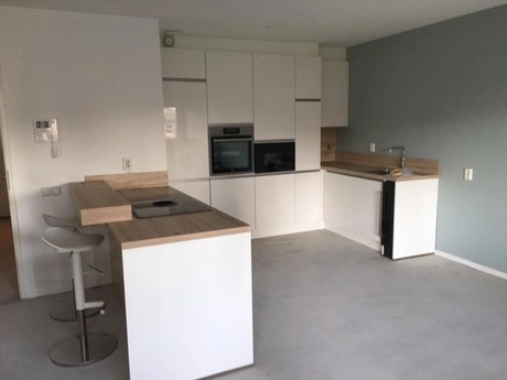 moderne keuken met witte kasten en barkrukken