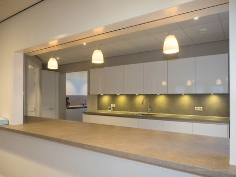 moderne keuken met witte kasten en verlichting