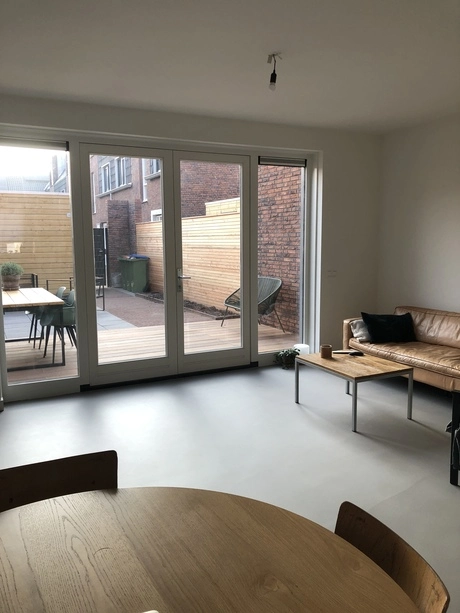 effen gietvloer in moderne woonkamer met tuin