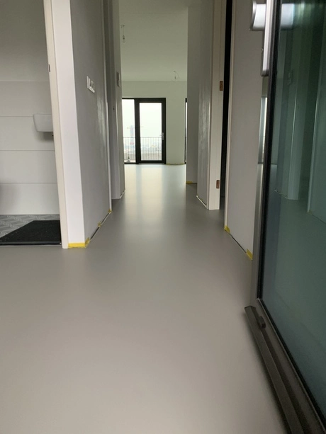 glad gietvloer in lichte gang zichtbaar