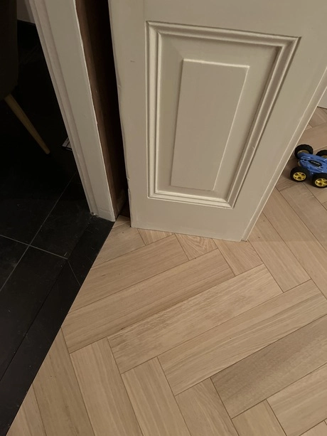 houten vloer met visgraatpatroon en deur