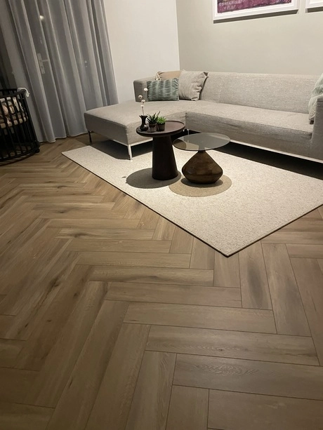 modern woonkamer met grijze bank en houten vloer
