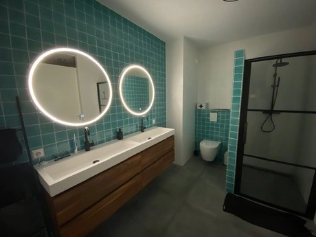 moderne badkamer met groene tegels en spiegels