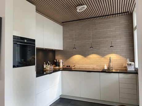 moderne keuken met witte kasten en hanglampen