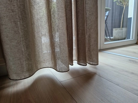 gordijnen hangen voor een zonnig raam