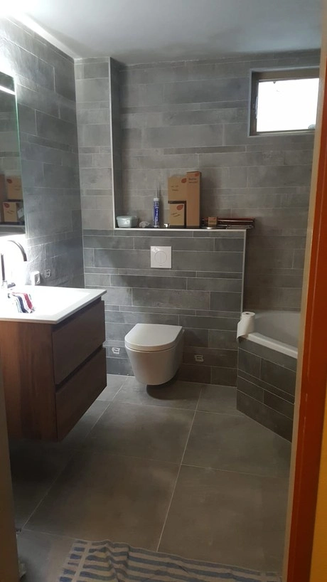 grijze badkamer met wastafel en toilet