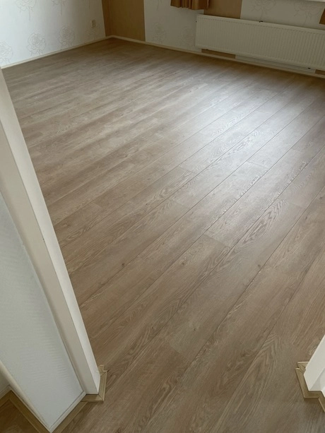 lege kamer met een houten laminaatvloer