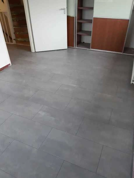 lege kamer met grijze tegelvloer en kasten