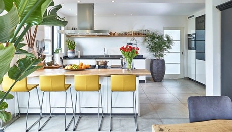 moderne keuken met gele barkrukken en planten