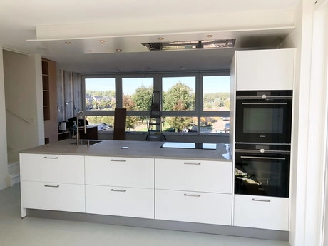 moderne witte keuken met grote ramen en eiland