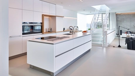 moderne witte keuken met kookeiland en trap