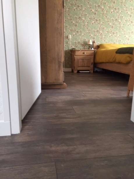 slaapkamer met houten meubels en bloemenbehang