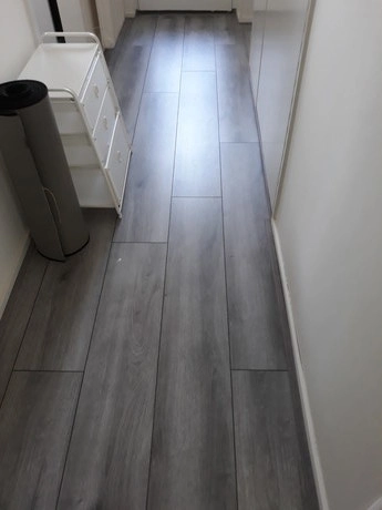 smal pad met grijze houten vloer in gang