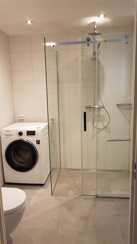 badkamer met douche en wasmachine