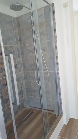 glazen douche met marmeren wandtegels