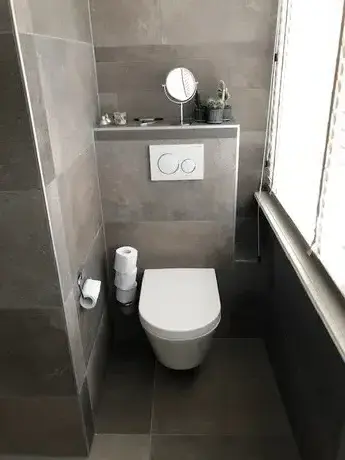 moderne badkamer met toilet en grijze tegels