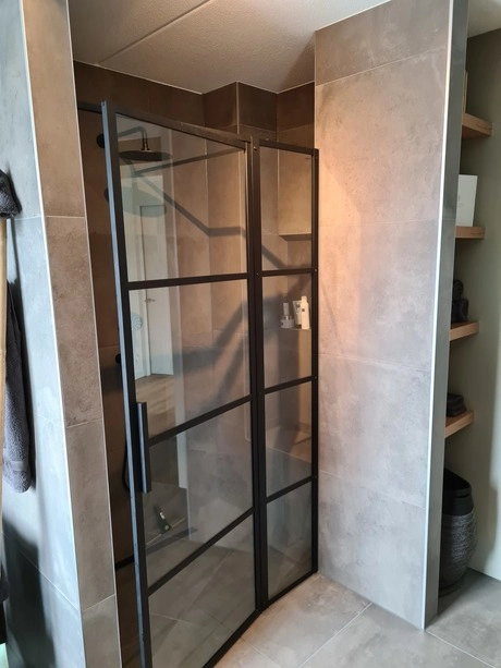 moderne douche met glazen deur en zwarte accenten