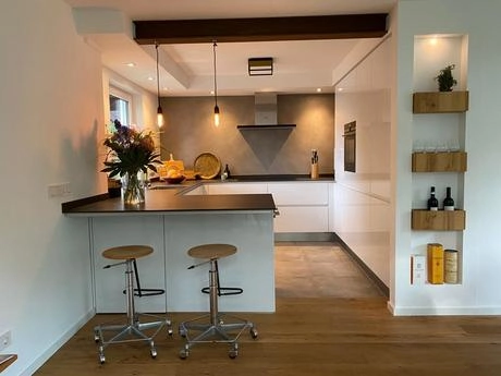 moderne keuken met houten vloer en barkrukken