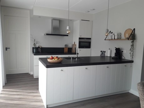 moderne keuken met witte kasten en fruitmand