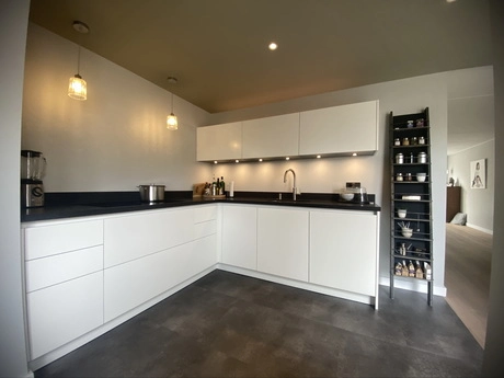moderne keuken met witte kasten en zwarte accenten