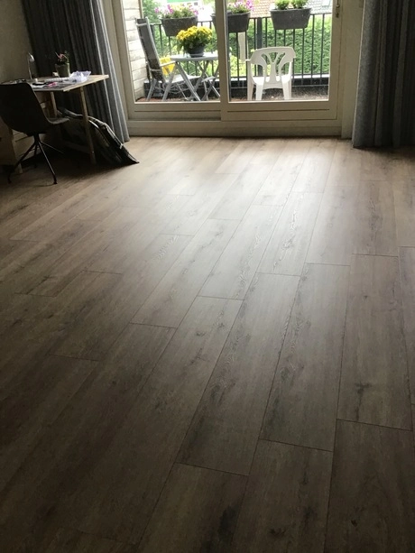 woonkamer met houten vloer en groot raam