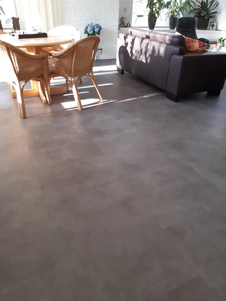 zonnige woonkamer met bank en eettafel