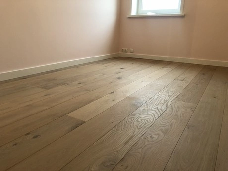 lege kamer met houten vloer en raam