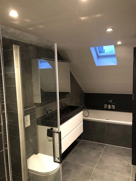 moderne badkamer met glazen douchecabine en bad