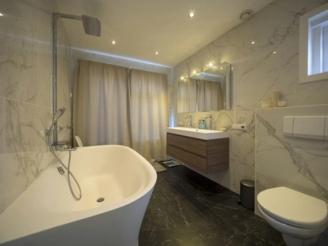 moderne badkamer met marmeren muren en bad