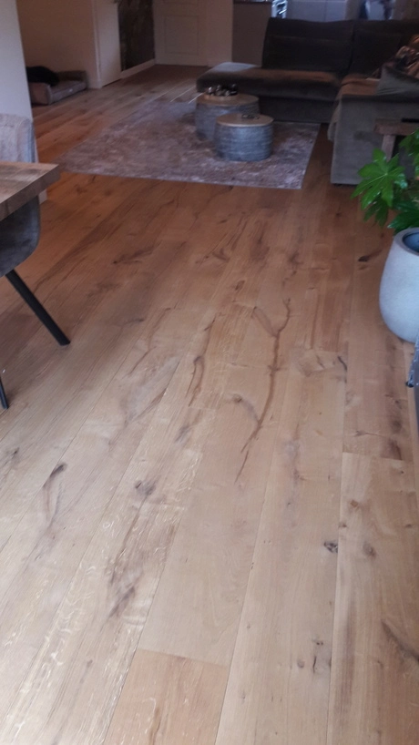 de woonkamer heeft een houten vloer