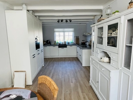heldere keuken met houten vloer en kasten
