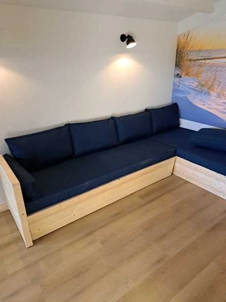 houten hoekbank met blauwe kussens in kamer